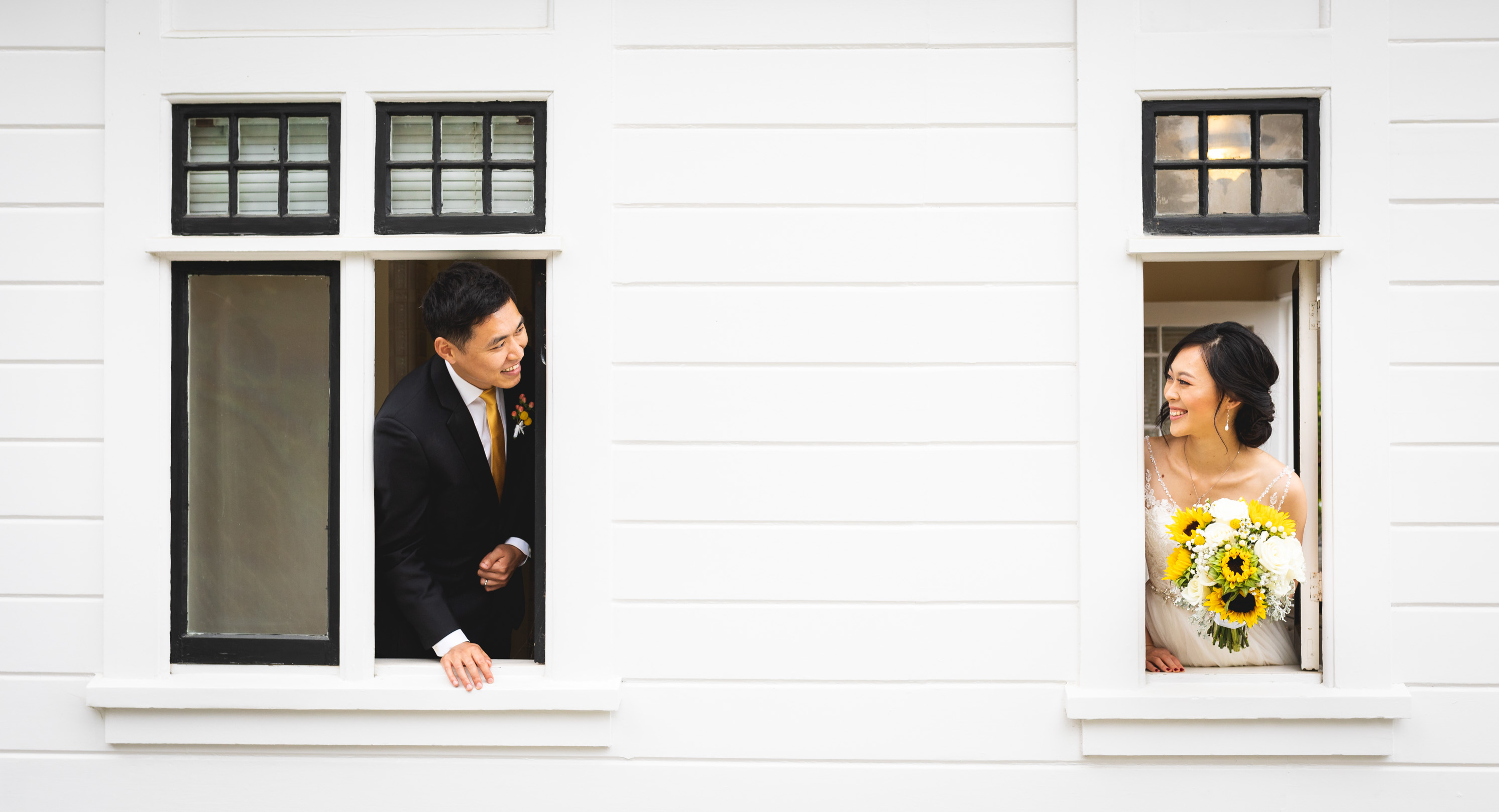 bride and groom peaking out window